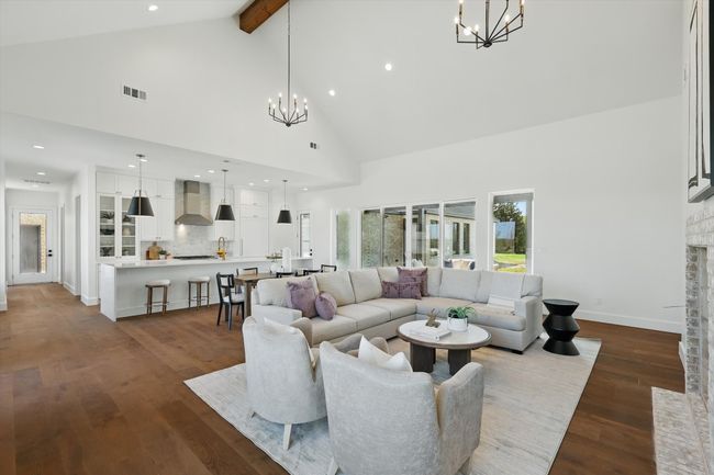 Living room featuring dark wood-style floors, visible vents, beamed ceiling, and a chandelier | Image 12