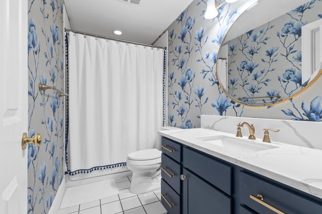 Lower level full guest bathroom with combination shower/tub and ceramic tile flooring is perfect for guests and everyday use. | Image 21