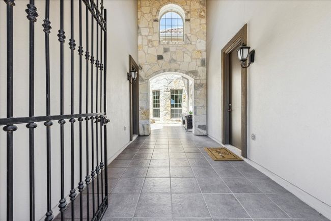 Hallway with tile patterned flooring and a towering ceiling | Image 4