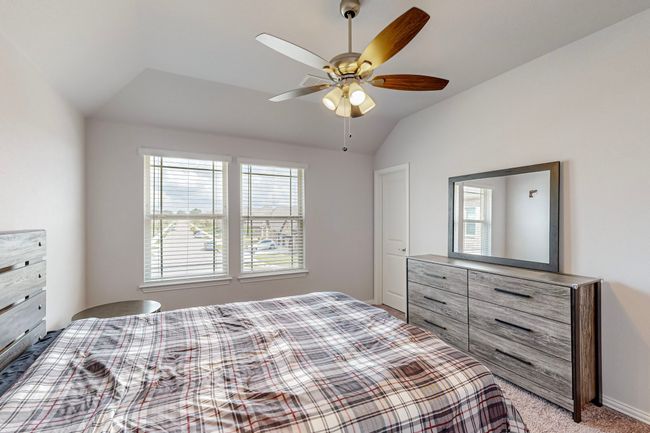 Bedroom with light carpet, vaulted ceiling, and a ceiling fan | Image 21