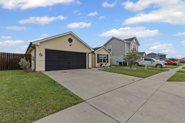 Single story home with concrete driveway, a garage, and brick siding | Image 30