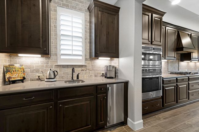 Kitchen with double oven, a sink, refrigerator, tasteful backsplash, and light countertops | Image 14
