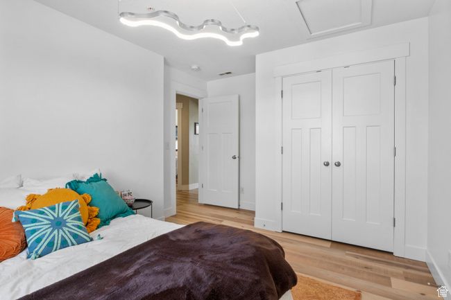 Bedroom with a closet, baseboards, light wood-type flooring, and attic access | Image 21