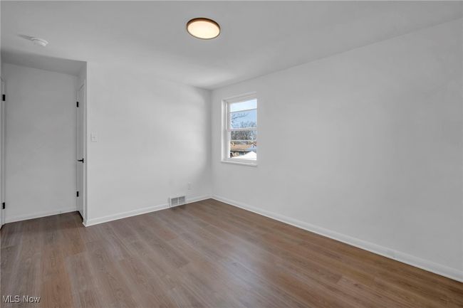 Unfurnished room with visible vents, baseboards, and wood finished floors | Image 22