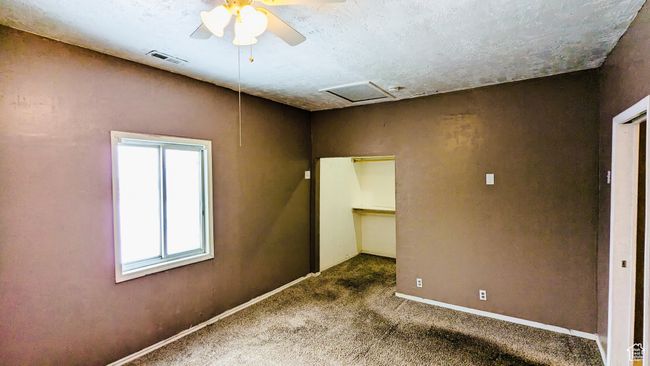 Carpeted spare room featuring a textured ceiling and ceiling fan | Image 35