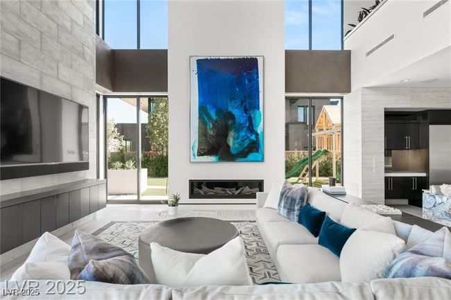 Living room with a towering ceiling and a glass covered fireplace | Image 17