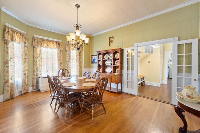 Dining area with a chandelier, ornamental molding, wood finished floors, and french doors | Image 12
