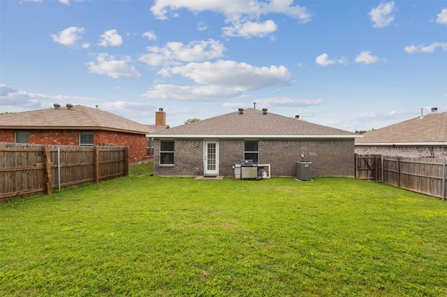 Back of house featuring central air condition unit, brick siding, a chimney, and roof with shingles | Image 29