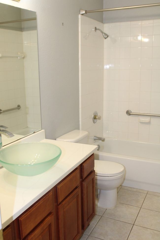 Full bathroom with toilet, shower / bathing tub combination, tile patterned flooring, and vanity | Image 9