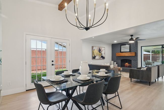 Dining room with light wood-type flooring, plenty of natural light, a fireplace, beam ceiling, and ornamental molding | Image 15