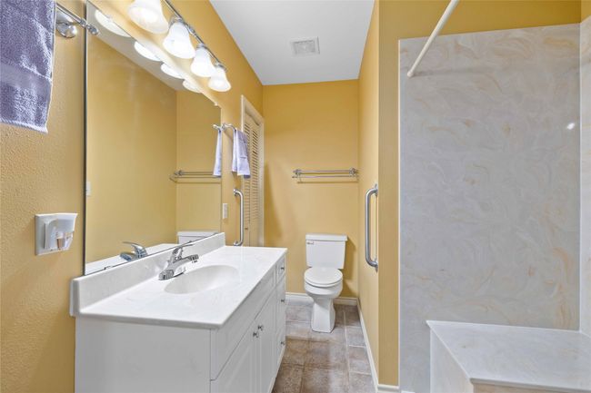 Guest bathroom with vanity and walk in shower with bench. | Image 23