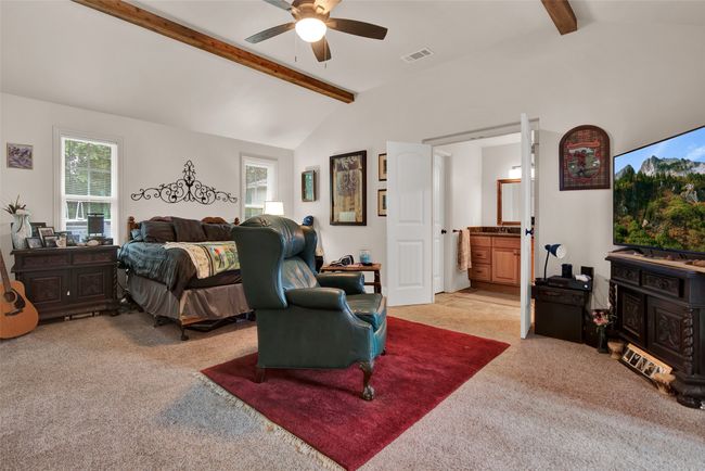 Primary suite two shines with style and space. Again, beams highlight this lovely room. There is a large closet in this room as well as exterior access to the patio area. | Image 22