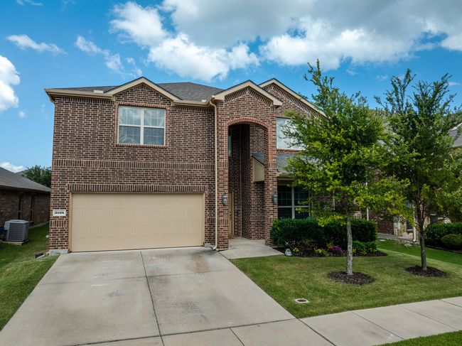 Traditional-style home with brick siding, a front yard, a garage, and concrete driveway | Image 23