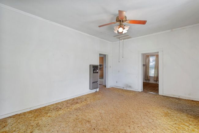 Empty room featuring a ceiling fan, light carpet, baseboards, and ornamental molding | Image 6