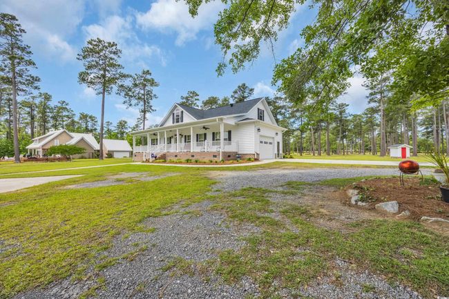 View of front of house with covered porch, crawl space, gravel driveway, and a front yard | Image 40
