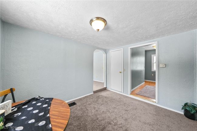 Dining room with a textured ceiling and carpet flooring | Image 5