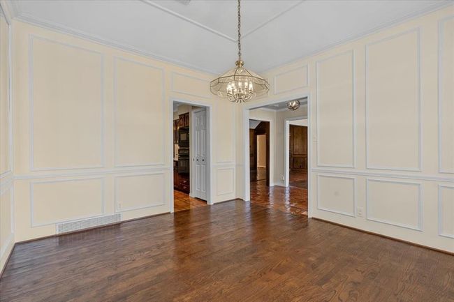 Unfurnished dining area featuring an inviting chandelier, crown molding, and dark hardwood / wood-style floors | Image 17