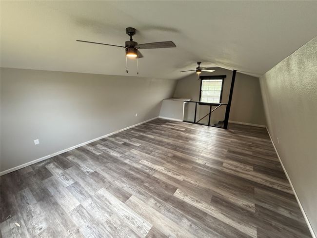 Additional living space with ceiling fan, dark wood finished floors, and vaulted ceiling | Image 33