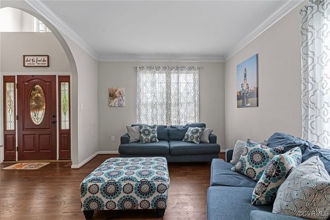 Living area with ornamental molding, arched walkways, wood finished floors, and baseboards | Image 23