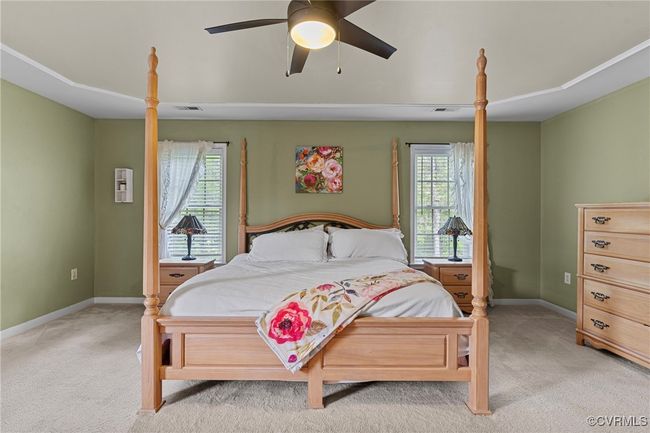 Bedroom featuring baseboards, light carpet, multiple windows, and ceiling fan | Image 28