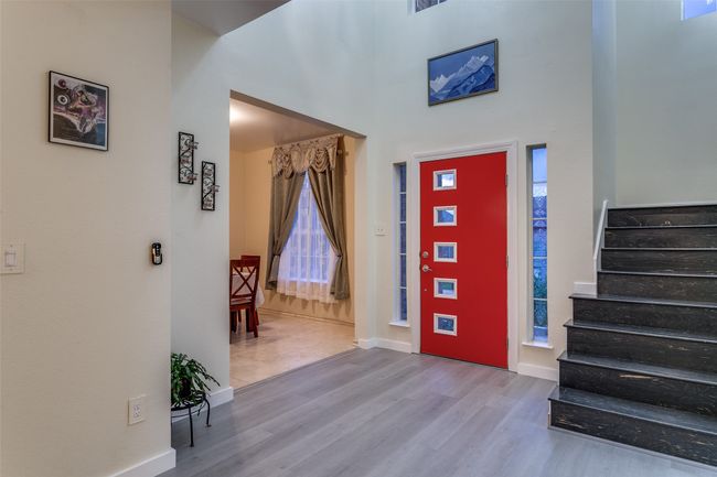 Entrance foyer featuring wood finished floors, baseboards, stairway, and a high ceiling | Image 5