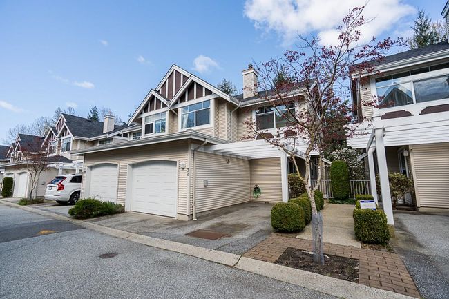 Multi unit property featuring an attached garage, a residential view, driveway, and a chimney | Image 33