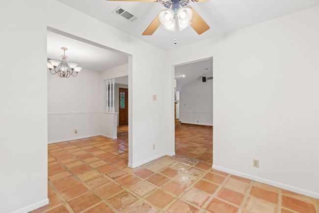 Spare room with ceiling fan and a chandelier | Image 16