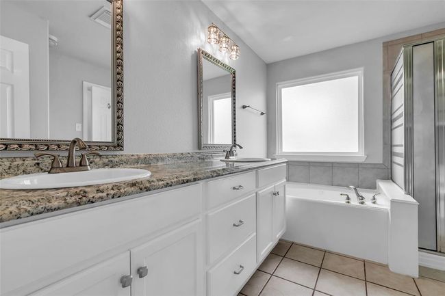 Primary bathroom with double sinks, soaking tub, and separate shower. | Image 26