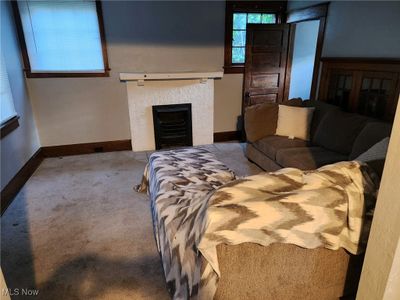 Carpeted living room with a tile fireplace | Image 3