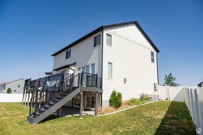 Rear view of property with stairway, a deck, a fenced backyard, and board and batten siding | Image 4
