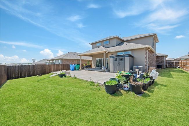 Back of property with a patio area, a fenced backyard, stucco siding, and a lawn | Image 29