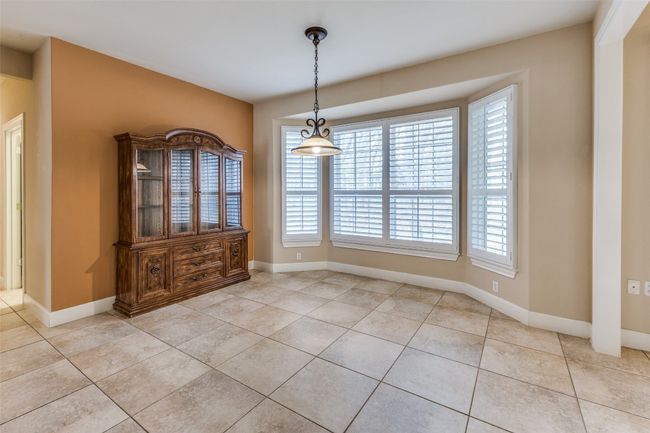 Unfurnished dining area with light tile patterned floors and baseboards | Image 6