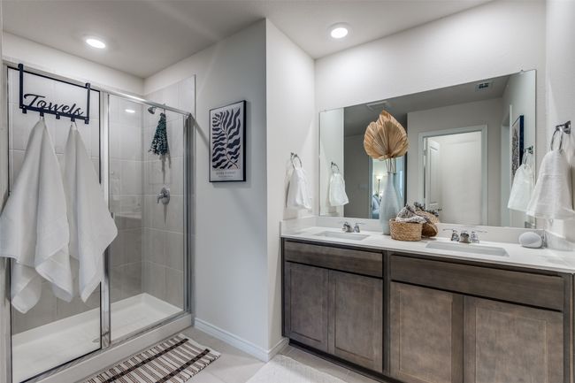 Primary Bathroom View 2 featuring a shower stall, double vanity, tile patterned floors. | Image 16