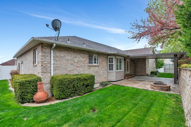 Rear view of property featuring fence, a fire pit, a yard, and a patio | Image 33
