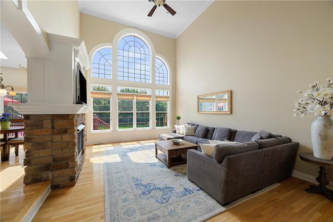 The two-story family room is the centerpiece of this home providing a magnificent array of floor-to-ceiling windows providing amazing views. A double-sided fireplace to the kitchen provides a relaxing atmosphere. | Image 13