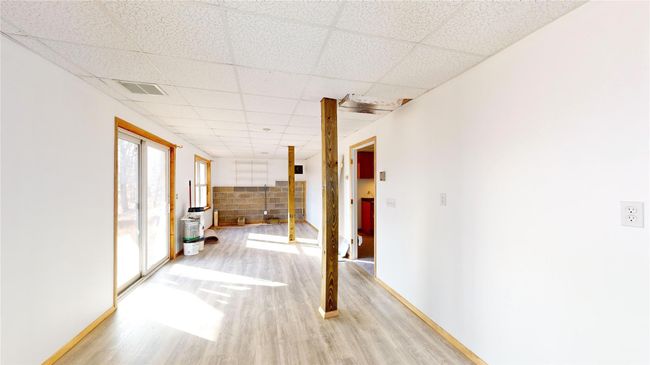 Hall with visible vents, light wood-style flooring, baseboards, and a drop ceiling | Image 29