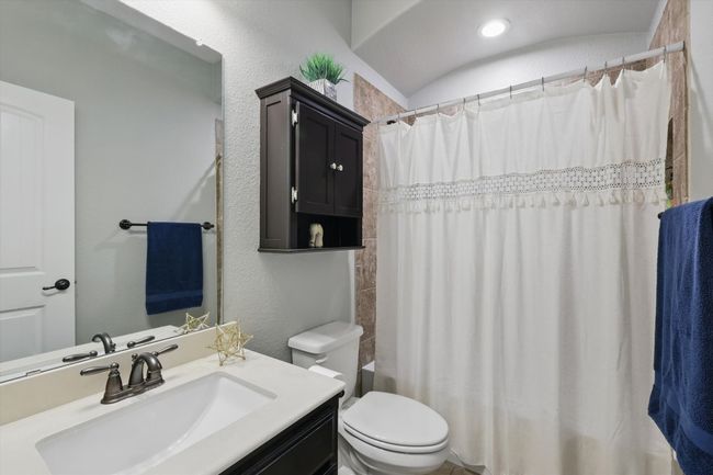 Bathroom with toilet, shower / bathtub combination with curtain, and vanity | Image 27