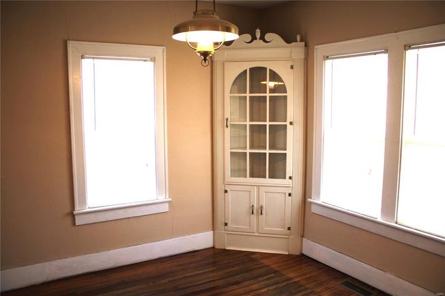 Unfurnished dining area with dark wood-type flooring, plenty of natural light, visible vents, and baseboards | Image 6