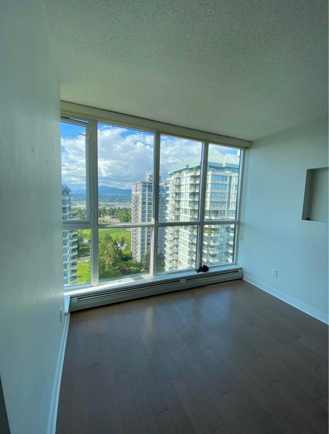 Unfurnished room featuring a textured ceiling, a view of city, a baseboard heating unit, and baseboards | Image 7