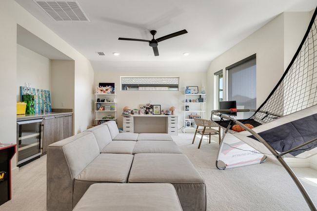 Living room with beverage cooler, light carpet, ceiling fan, and a dry bar | Image 29
