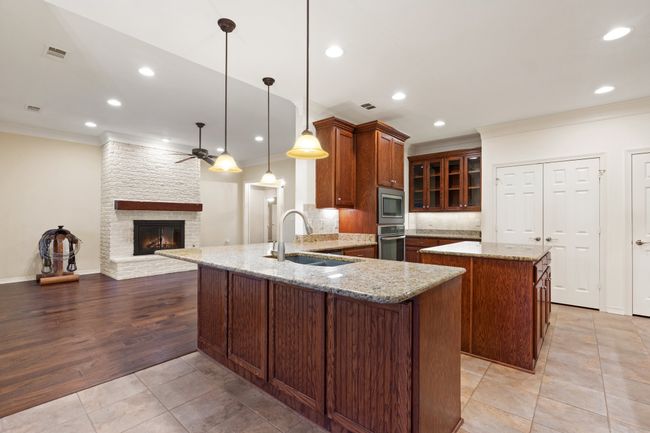 Kitchen featuring a sink, appliances with stainless steel finishes, crown molding, ceiling fan, and a peninsula | Image 8