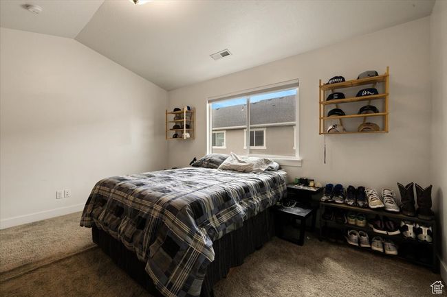 Carpeted bedroom featuring vaulted ceiling, visible vents, and baseboards | Image 12