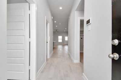 As you step into the threshold of this luxurious home, you'll soon be welcomed by an elegant glass door. Inside, soaring ceilings amplify the spaciousness, while the refined wood-look tile flooring and oversized baseboards exude sophistication and charm. Sample photo of similar plan. As-built color and selections may vary. | Image 3