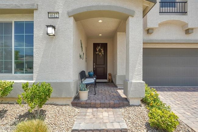 Property entrance with stucco siding, a garage, and decorative driveway | Image 8