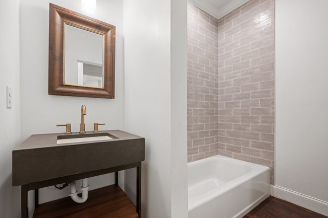 Bathroom with wood finished floors and shower / washtub combination | Image 21