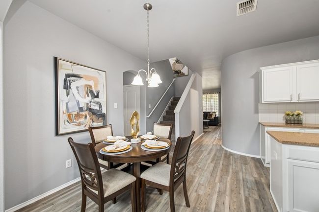 Dining room with visible vents, baseboards, light wood-type flooring, and stairway | Image 15