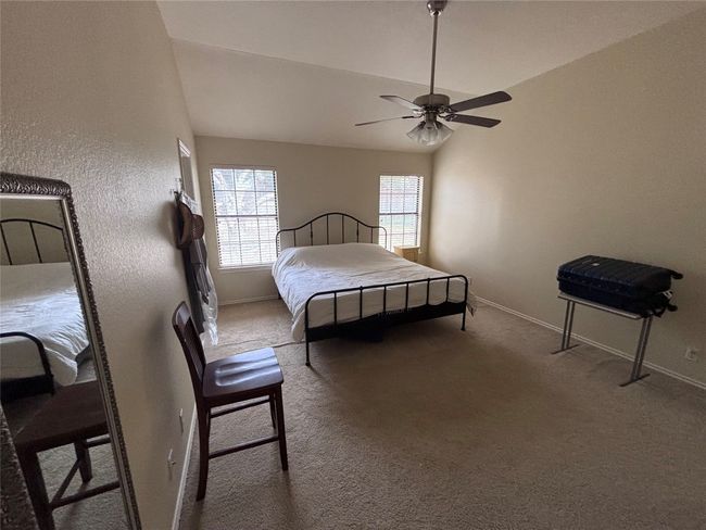 Carpeted bedroom with a ceiling fan and lofted ceiling | Image 14