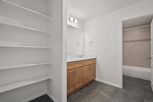 Full bathroom with vanity, tile patterned flooring, and bathing tub / shower combination | Image 21