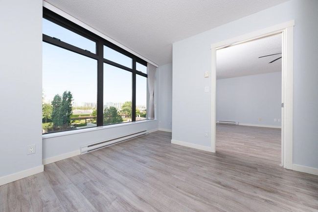 Spare room featuring a textured ceiling, wood finished floors, baseboard heating, and a baseboard radiator | Image 13