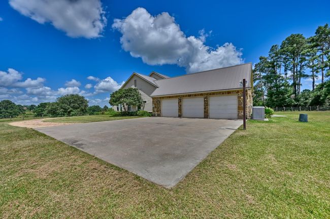 This property features a spacious three-car garage with a wide driveway. | Image 39
